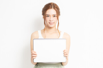 Fototapeta premium 白紙のスケッチブックを持つ若い女性