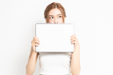 Fototapeta premium 白紙のスケッチブックを持つ若い女性