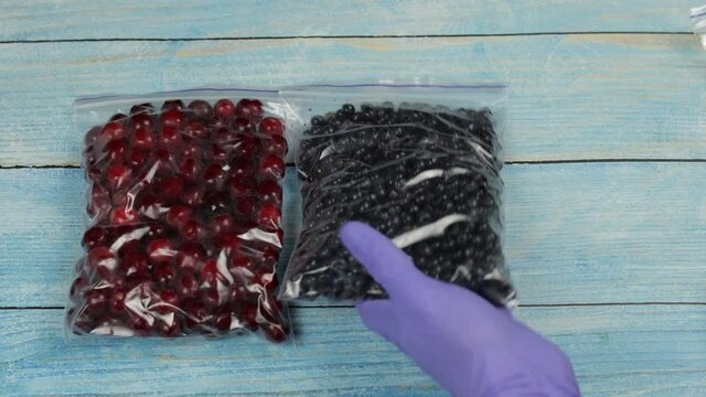 Packages with blueberry, cherry, raspberry in zipper plastic bags for freezing. Frozen berries food