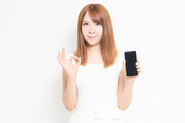 Fototapeta premium スマホを持つワンピースを着た女性