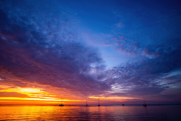 Sunset or sunrise in ocean or sea, nature landscape background. Sunset sea beach. Blue sea and reflection of sunlight.