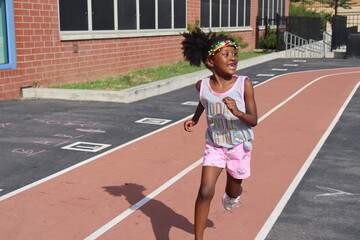 Cute black girl running around full body shot on summer day