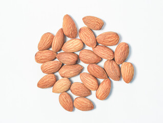 A picture many natural dry almond seeds on a white background, top-down corner