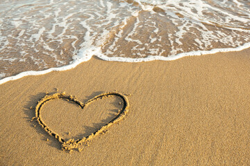 Obraz na płótnie Canvas Drawn Heart on the sand of a sea tropical beach.