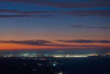 zoom shot, colorful sky after sunset and the lights of the city of Puerto Varas