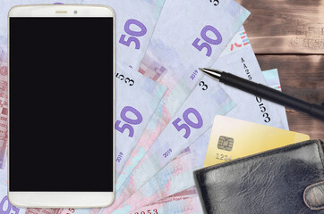 50 Ukrainian hryvnias bills and smartphone with purse and credit card. E-payments or e-commerce...