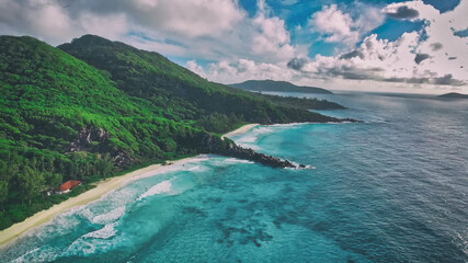 Tropical beach with sea and palm taken from drone. Seychelles famous beach - aerial photo of La Digue Grand Anse