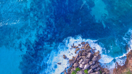 Amazing overhead aerial view of island shoreline with waves along the ocean