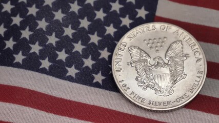 Silver dollar and an American flag Cash . Finance, investment concept and crisis . Closeup shot Silver 1oz  - Powered by Adobe