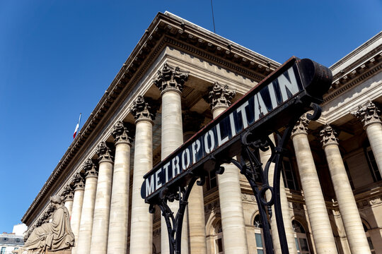 Paris, France - September 02 2019: Metropolitain sign with Paris Bourse stock exchange building (Brongniart palace) in background.