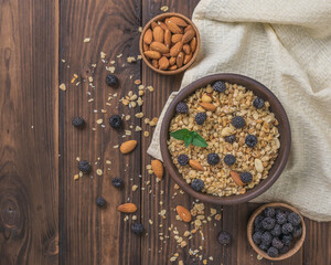 Fresh berries, almonds and granola on a wooden table.