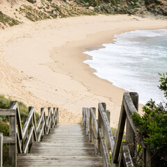 Wooden stairs leading down to the beach shore.