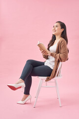 Asian female Reading Book on Chair, Full Body Isolated on pink.