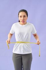 Fototapeta premium woman unhappy with her body, the diet, the body measures the isolated violet background