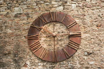 Metallic clock on a stone wall