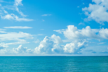 沖縄のさわやかな青空と夏の雲と穏やかな海と水平線