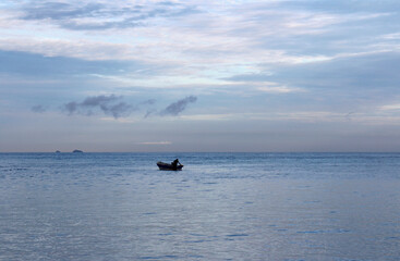 View of dawn at the seaside with a man on the boat, Tioman Island