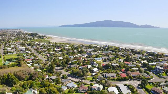 Tilting drone shot of Kapiti Island and coastline