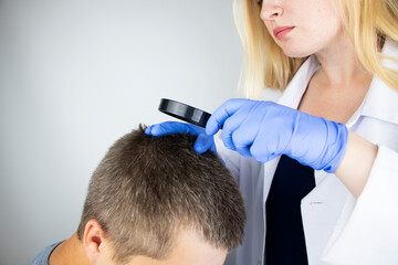 A trichologist examines the hair of a man who begins alopecia. Consultation with a dermatologist. Hair loss, alopecia, pruritus, burning head or seborrhea