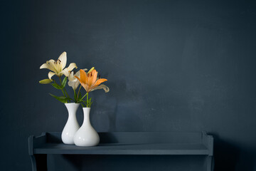 bouquet of lily flowers in vase on dark background