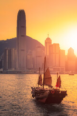 Hong Kong traditional tourists boat for tourist service in victoria harbor with city view in background at sunset,view from Kowloon side at Hong Kong