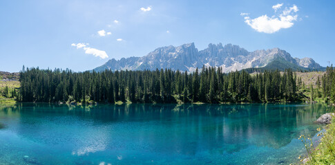 Scenic view of picturesque Lago di Carezza mountain lake (Karersee) with famous crystal clear turquoise water reflections of deep fir woods and beautiful Dolomite mountain tops, South Tyrol, Italy
