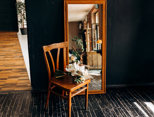 The bride's bouquet on a chair near the mirror. Morning of the bride