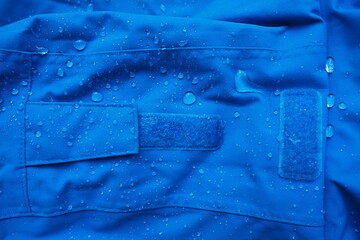 Closeup of water drops on dark blue fabric and sticky straps with waterproof design to protect fabric of the cloth from humidity and to offer easy cleaning to users Fabric texture with design