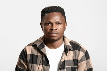 Sad African-American man on light background. Stop racism