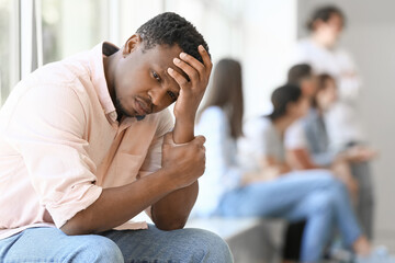 Lonely African-American man near window in hall. Stop racism