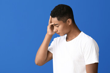 Sad African-American teenage boy on color background. Stop racism