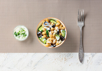 Bowl with tasty pasta salad on table