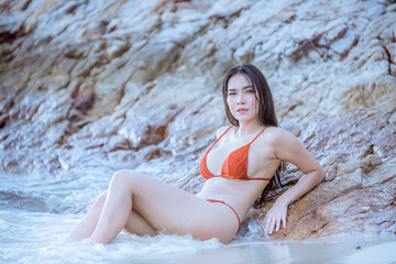Fototapeta premium Portrait beautiful young model asian woman wearing swimming suite bikini posing sexy feel happy on the sea ocean beach for leisure travel vacation on summer season. 