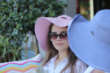 two girls are sitting in a cafe drinking coffee and taking selfies