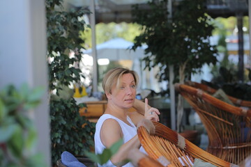 two girls are sitting in a cafe drinking coffee and taking selfies