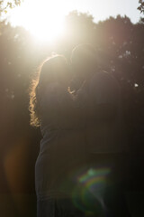 Happy and young pregnant couple in park in summer