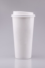 Takeaway white coffee cup with blank area on grey background.