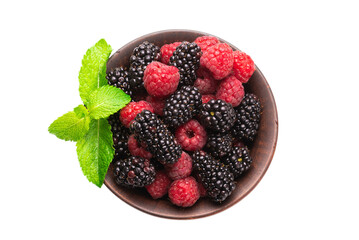 Raspberry, blackberry and mint leaf in ceramic brown bowl isolated on white