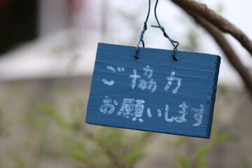 枝にかけてあるご協力お願いしますと書かれたプレート中央Thank you for your cooperation. Bulletin board written in Japanese.