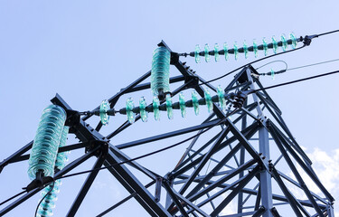 High-voltage transmission line with a plurality of insulators in close-up.