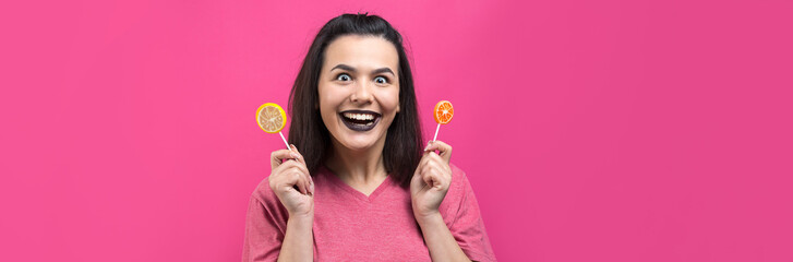 Portrait of lovely sweet beautiful cheerful woman with straight brown hair holding a lollipop near the eyes.