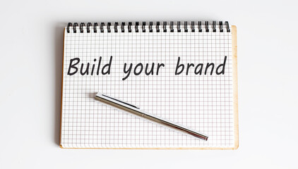 Concept BUILD YOUR BRAND message on notebook on white background