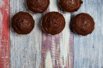 several chocolate cupcakes with decorations in the upper part of the image