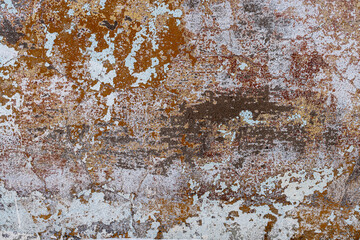 Peeling paint on the wall. Old concrete wall with cracked flaking paint. Weathered rough painted surface with patterns of cracks and peeling. Grunge texture for background and design. High resolution.