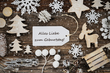 One White Label With German Text Alles Liebe Zum Geburtstag Means Happy Birthday. Frame Of Christmas Decoration Like Tree, Sled, Star And Fir Cone. Wooden Background With Snowflakes