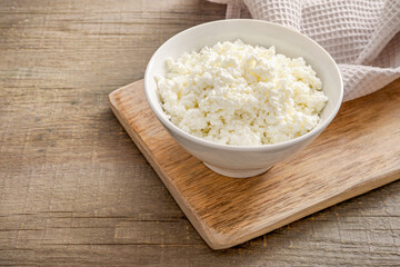 Fresh cottage cheese on rustic table