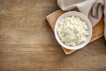 Fresh cottage cheese on rustic table