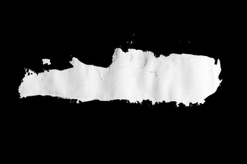 Brushstroke with a thick white paint, isolated on a black background.