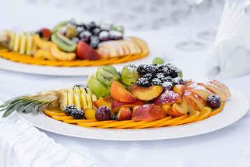 fruit sliced ​​on a white plate sprinkled with icing sugar