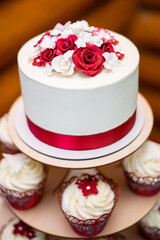 Obraz na płótnie Canvas wedding white cake with decorative red ribbon